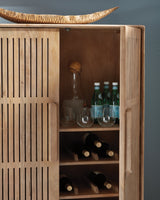Ashley Furniture Pellamour accent bar cabinet with wood finish and decorative hardware, displayed in a stylish living space.