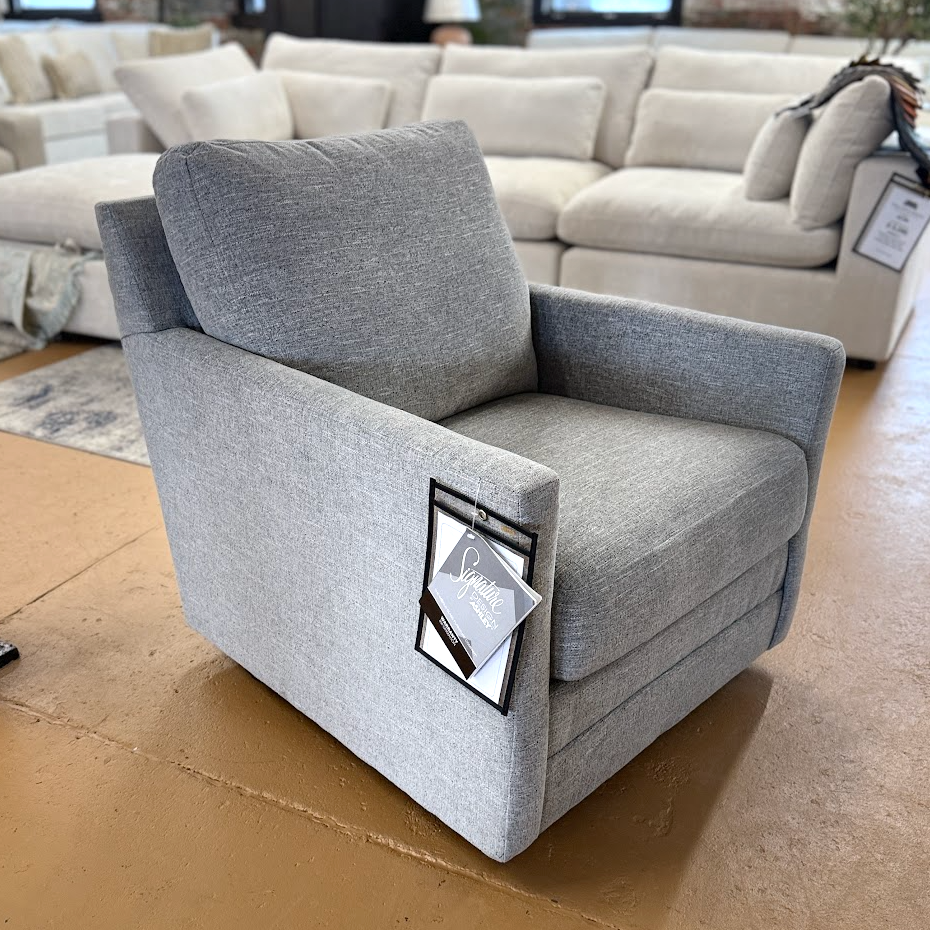 Ashley Furniture Freybourne swivel accent chair with plush fabric upholstery and modern design, shown in a cozy living space.
