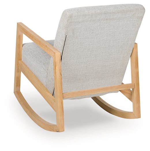 Ashley Furniture Wychworth accent chair with dark wooden legs and plush beige upholstery, shown from the back.