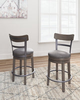 Ashley Furniture Caitbrook counter height bar stool with wooden legs and upholstered seat, shown in a modern kitchen setting.