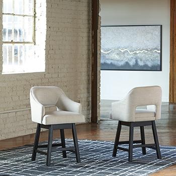 Set of Ashley Furniture Tallenger barstools with wooden legs and cushioned seats, ideal for kitchen or bar area.