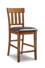 Set of two Ashley Furniture Ralene Bar Stools with wooden legs and upholstered seats, ideal for kitchen or bar area.