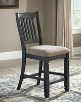 Set of Ashley Furniture Tyler Creek barstools with wooden seats and black metal legs, arranged around a high dining table.