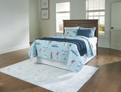 Ashley Furniture Danabrin panel storage bed with built-in drawers and a modern wood finish, shown in a well-lit bedroom setting.