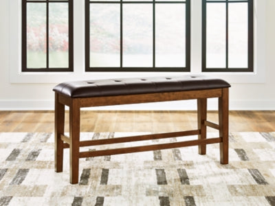 Ashley Furniture Ralene counter height dining bench with wooden finish and cushioned seat, ideal for kitchen or dining room seating.
