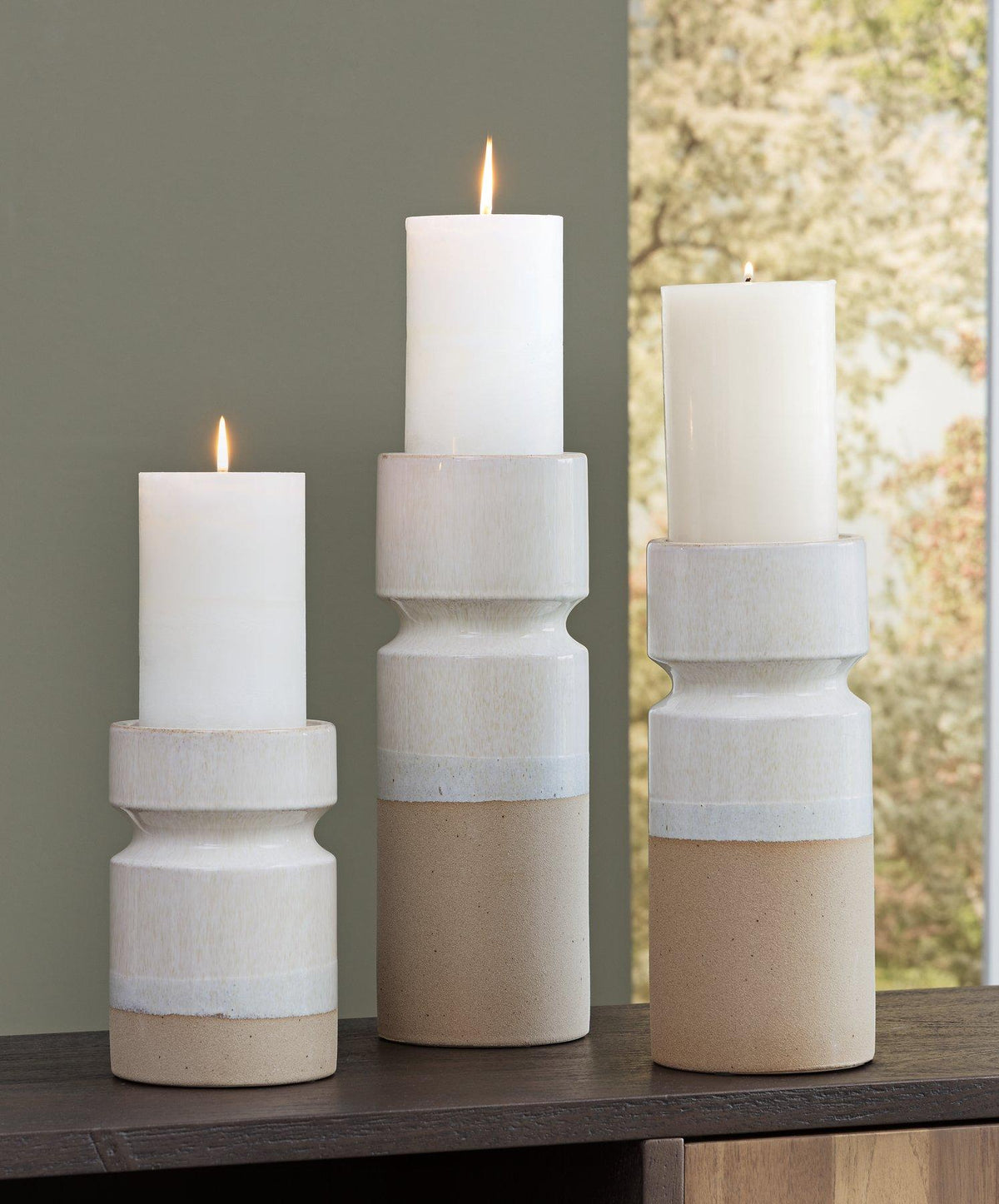 Set of three Ashley Furniture Hurston Candle Holders with rustic metal finish and varied heights for decorative tabletop display.