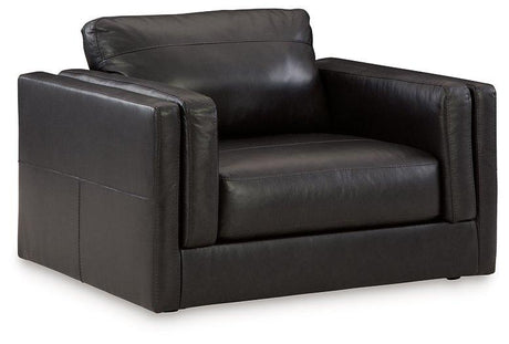 A large, plush Amiata Oversized Chair by Ashley Furniture with soft fabric upholstery and wide armrests.