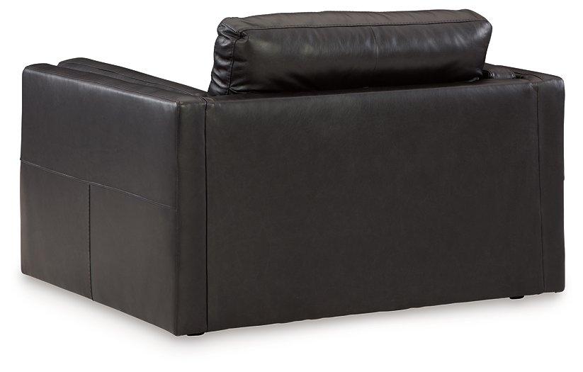 Ashley Furniture Amiata oversized chair with plush upholstery and wide armrests, shown in a stylish living room setting.