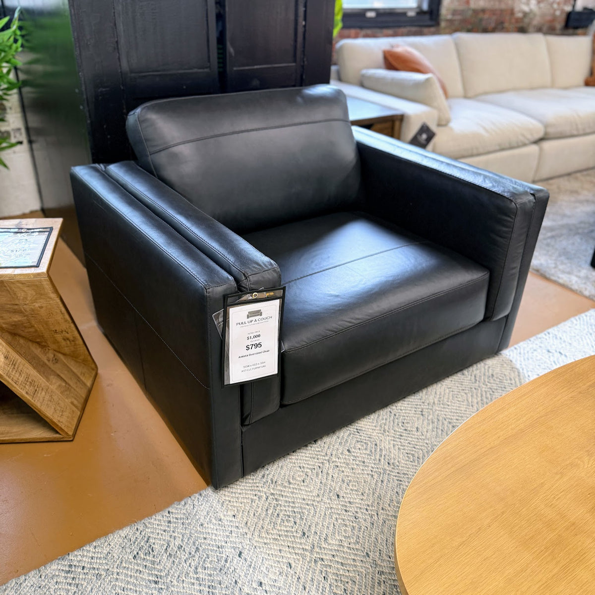 A large, plush Amiata oversized leather chair by Ashley Furniture with soft brown leather upholstery and a modern design.