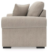 Ashley Furniture Sararose Oversized Chair in beige fabric with plush cushioning and wide armrests, shown from the side.