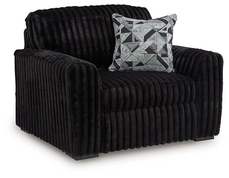 Ashley Furniture Midnight-Madness oversized chair with plush fabric and wide armrests, shown from an angled side view.