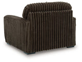 Ashley Furniture Midnight-Madness oversized chair with plush fabric and wide armrests, shown from the back in a cozy living room setting.