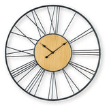 Ashley Furniture Brockett wall clock with a round design and modern style, hanging on a wall in a cozy living space.