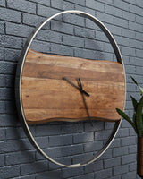 Ashley Furniture Panchali Wall Clock hanging on a wall, featuring a stylish design with a round face and modern clock hands.