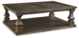 Ashley Furniture Johnelle coffee cocktail table with a sleek wooden surface and modern design, ideal for living room decor.