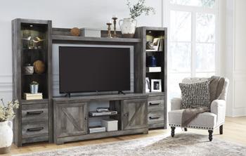 Four-piece Ashley Furniture Wynnlow entertainment center with TV stand, shelves, and storage cabinets in a modern style.