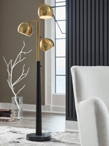 Ashley Furniture Sorcha floor lamp with a sleek metal base and fabric shade, standing tall in a modern living room setting.