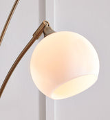 Taliya arc floor lamp by Ashley Furniture with a sleek design and curved arm, standing tall with a modern aesthetic.