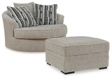 Ashley Furniture Calnita living room set with a sofa and armchair, featuring neutral upholstery and modern design elements.