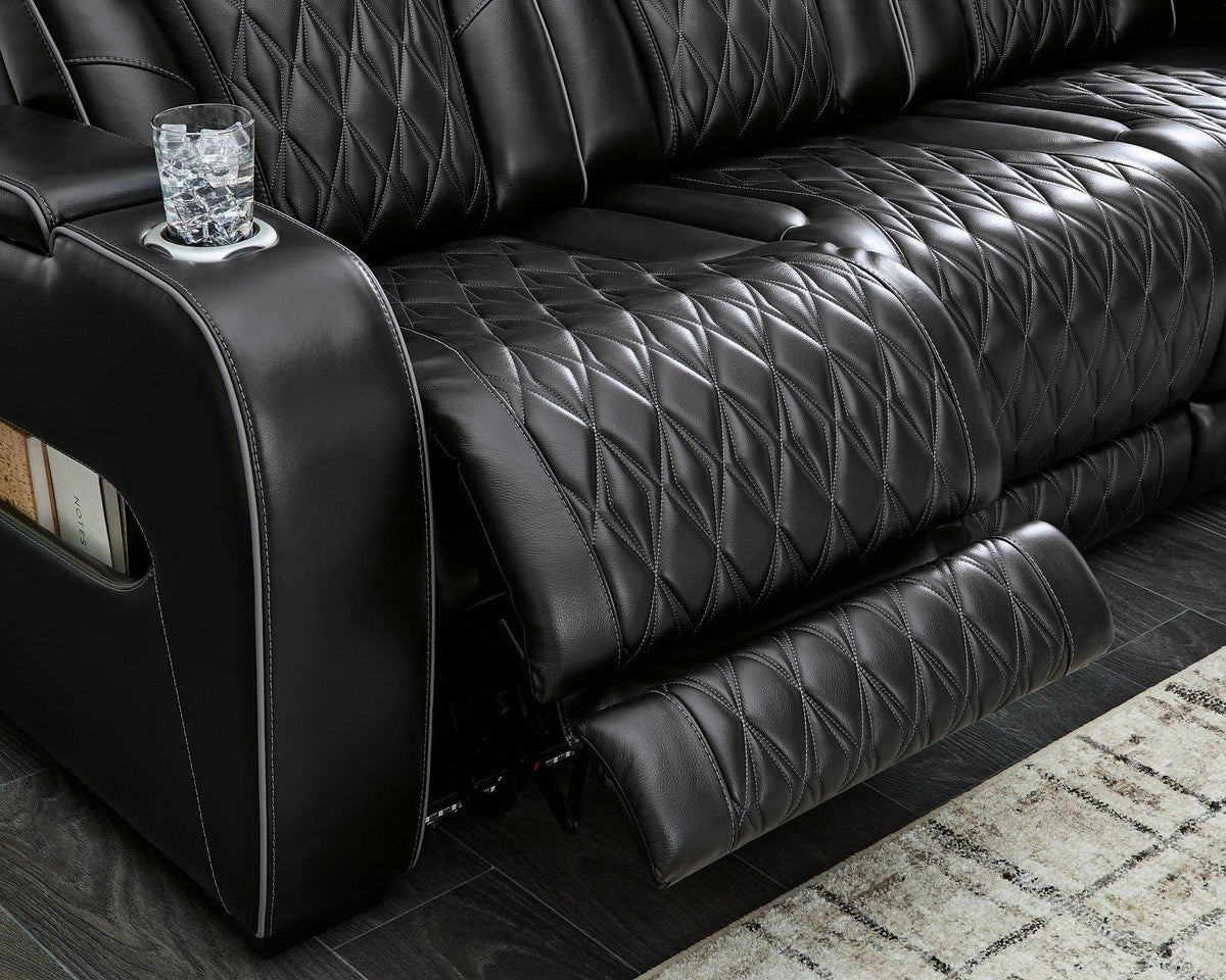 Ashley Boyington power reclining loveseat with console, showing plush fabric, built-in cup holders, and padded armrests.