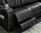 Ashley Boyington power reclining loveseat with console, showing plush fabric, built-in cup holders, and padded armrests.