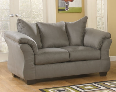 Ashley Furniture Darcy Loveseat with plush fabric and cushioned arms, shown in a cozy living room setting.