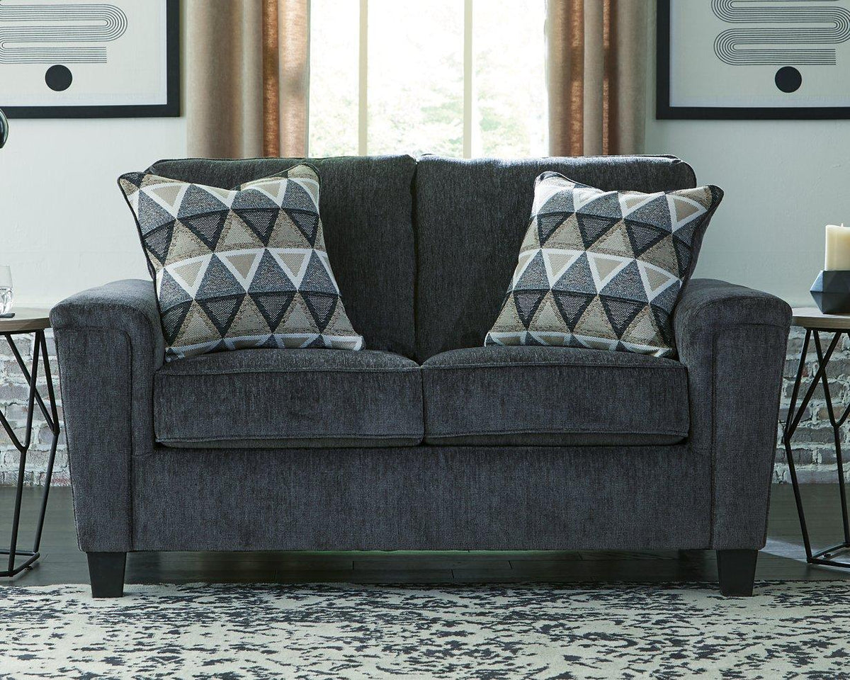 Ashley Furniture Abinger loveseat showing plush beige fabric, cushioned armrests, and cozy seating for two.