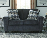 Ashley Furniture Abinger loveseat showing plush beige fabric, cushioned armrests, and cozy seating for two.