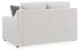 Ashley Furniture Adda loveseat with plush cushions and dark fabric upholstery, shown from the back in a contemporary living room setting.