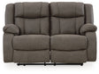 Ashley Furniture First Base reclining loveseat with plush cushions and reclining features, shown in a head-on view.