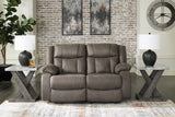 Ashley Furniture First Base reclining loveseat with plush cushions and fabric upholstery, shown in a closed position.