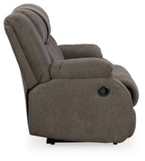 Ashley Furniture First Base reclining loveseat with plush cushions and wide armrests, shown from a side angle.