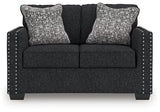 Ashley Furniture Jasmine Peaks loveseat showing plush beige upholstery and cushioned armrests, ideal for cozy living room seating.
