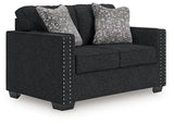 Ashley Furniture Jasmine Peaks loveseat with plush cushions and wooden legs, shown from an angled view.