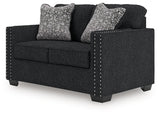 Ashley Furniture Jasmine Peaks loveseat showing plush beige fabric, cushioned armrests, and stylish design from an angled view.