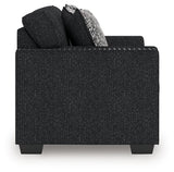 Ashley Furniture Jasmine Peaks loveseat featuring plush fabric and cushioned armrests, shown from a side view.