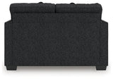 Ashley Furniture Jasmine Peaks loveseat with plush fabric and cushioned backrest, shown in a cozy living room setting.