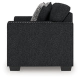 Ashley Furniture Jasmine Peaks loveseat with plush fabric and cushioned armrests, shown in a cozy living room setting.
