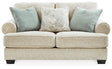Ashley Furniture Monaghan loveseat with plush upholstery and tufted back in a cozy living room setting.