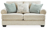 Ashley Furniture Monaghan loveseat with plush upholstery and tufted back in a cozy living room setting.
