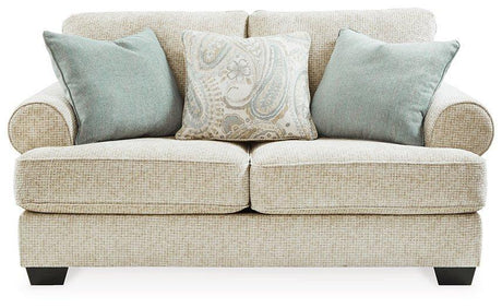 Ashley Furniture Monaghan loveseat with plush upholstery and tufted back in a cozy living room setting.