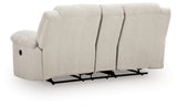 Ashley Furniture Orlen reclining loveseat with console, showing plush fabric, padded armrests, and built-in cup holders in a cozy living room setting.