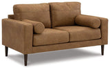 Ashley Telora loveseat showing plush beige fabric upholstery and cushioned armrests for comfortable seating.
