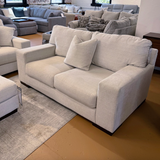 Ashley Furniture Newport Loveseat with plush beige upholstery and cushioned armrests, ideal for cozy living room seating.