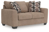 Ashley Furniture Triston-Peaks loveseat with plush cushions and wooden legs, shown from an angled view.