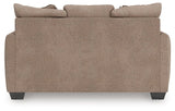 Ashley Furniture Triston-Peaks loveseat with plush fabric, rolled arms, and cushioned back in a cozy, stylish design.