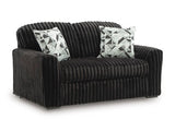 Ashley Furniture Midnight-Madness loveseat with plush dark upholstery and cozy armrests, shown from an angled side view.