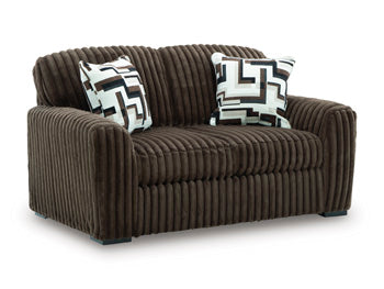 Ashley Furniture Midnight-Madness Loveseat showing plush gray upholstery and stylish armrests from a side angle.