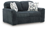 Ashley Furniture Midnight-Madness loveseat shown from an angled side view, featuring dark upholstery and plush cushions.
