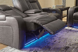 Ashley Furniture Fyne-Dyme power reclining loveseat with console, showing plush fabric, reclining mechanism, and built-in cup holders.